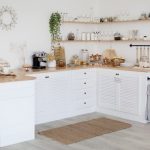 Cozy white kitchen interior without stove and sink made in rural style, comfortable warm light empty kitchen full of utensils, furniture, coffee machine. Home interiors concept