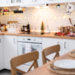 Interior background in a blur of white wooden kitchen of Festive Christmas decor and mess, festive breakfast, white scandi interior. New Year, mood, cozy home